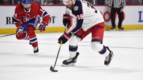 Feb 2, 2020; Montreal, Quebec, CAN; Columbus Blue Jackets forward Boone Jenner (38) plays the puck and Montreal Canadiens forward Nick Suzuki (14) defends during the third period at the Bell Centre.