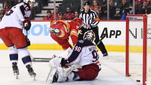 Feb 15, 2022; Calgary, Alberta, CAN; Calgary Flames forward Tyler Toffoli (73) scores on Columbus Blue Jackets goalie Elvis Merzlikins (90) during the third period at Scotiabank Saddledome. Flames won 6-2.