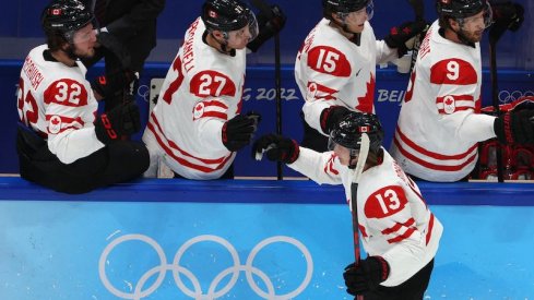 Team Canada's Kent Johnson celebrates a goal with teammates during Group A play versus China in the 2022 Winter Olympics in Beijing.