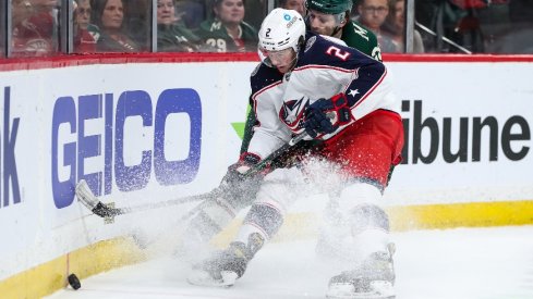Mar 26, 2022; Saint Paul, Minnesota, USA; Columbus Blue Jackets defenseman Andrew Peeke (2) and Minnesota Wild right wing Ryan Hartman (38) battle for the puck in the second period at Xcel Energy Center. 