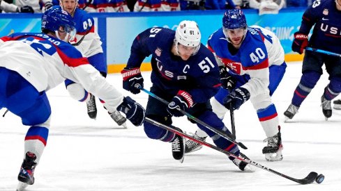 United States forward Andy Miele (51) and Slovakia defender Samuel Knazko (22) go for the puck in the men s ice hockey quarterfinal during the Beijing 2022 Olympic Winter Games