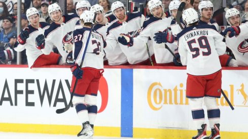 Columbus Blue Jackets defenseman Adam Boqvist (27) is congratulated by his team mates on his goal against Winnipeg Jets goalie Eric Comrie (1) during the first period at Canada Life Centre.