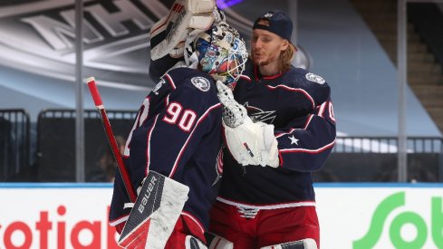 Goaltender Joonas Korpisalo of the Columbus Blue Jackets congratulates fellow netminder Elvis Merzlikins after an exhibition game against the Boston Bruins prior to the 2020 NHL Stanley Cup Playoffs.