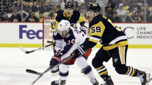 Columbus Blue Jackets center Cole Sillinger and Pittsburgh Penguins left wing Jake Guentzel chase the puck during the third period at PPG Paints Arena. The Penguins won 5-1.