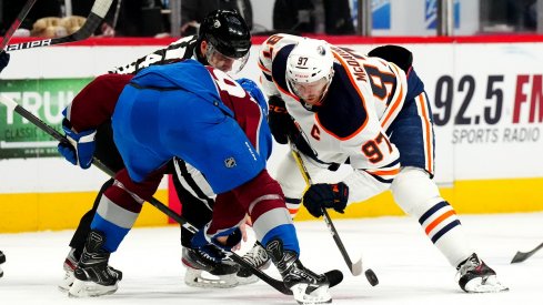 Nathan MacKinnon and Connor McDavid face off
