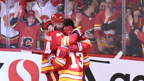 Calgary Flames defenseman Erik Gudbranson (44) forward Johnny Gaudreau (13) and forward Matthew Tkachuk celebrate the overtime win over the Dallas Stars in game seven of the first round of the 2022 NHL Playoffs.