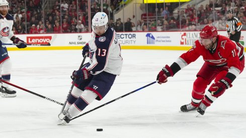 Columbus Blue Jackets' Johnny Gaudreau skates with the puck past Carolina Hurricanes' Jordan Staal during the second period at PNC Arena.