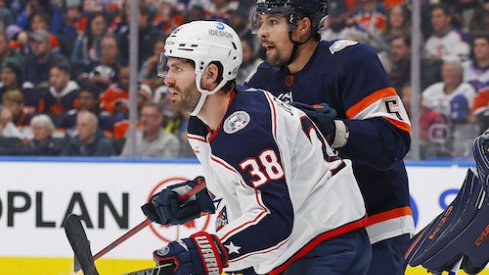 Boone Jenner and Cody Ceci battle in front of the net.