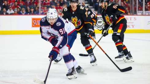 Kent Johnson skates with the puck against the Calgary Flames