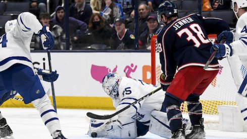 Maple Leafs goalie Petr Mrazek stops a puck while Boone Jenner is in the crease.