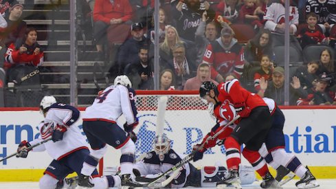 Elvis Merzlikins makes a save on Nathan Bastian in the Blue Jackets vs. Devils game.