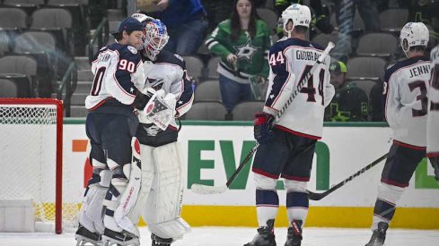 Columbus Blue Jackets' Elvis Merzlikins and Joonas Korpisalo and Erik Gudbranson celebrate the win over the Dallas Stars at the American Airlines Center.