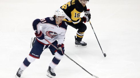 Kent Johnson carries the puck in the Blue Jackets vs. Penguins game.