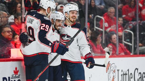 Columbus Blue Jackets' Patrik Laine celebrates his goal with Johnny Gaudreau and Jack Roslovic during the first period against the Detroit Red Wings at Little Caesars Arena.