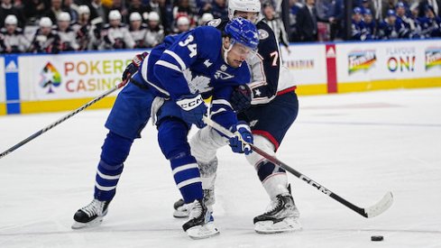 Toronto Maple Leafs forward Auston Matthews (34) gets held up by Columbus Blue Jackets forward Sean Kuraly (7) during the first period at Scotiabank Arena.