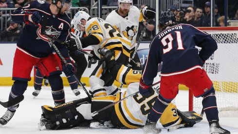 Pittsburgh Penguins' Tristan Jarry makes a save as Columbus Blue Jackets' Kent Johnson looks for a rebound against the Columbus Blue Jackets during the second period at Nationwide Arena.