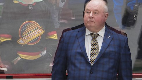 Vancouver Canucks head coach Bruce Boudreau watches from the bench during warm up prior to a game against the Arizona Coyotes at Rogers Arena.