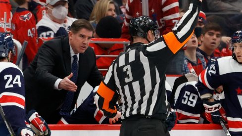 Washington Capitals head coach Peter Laviolette (L) argues a penalty call by referee Mike Leggo (3) during the game against the Vancouver Canucks during the third period at Capital One Arena.
