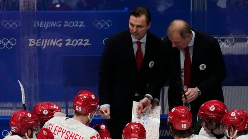 Team ROC head coach Alexei Zhamnov (R) and assistant coach Sergei Fedorov (M) talk to their team during a timeout against Team Finland in the final minute of the third period during the Beijing 2022 Olympic Winter Games at National Indoor Stadium.