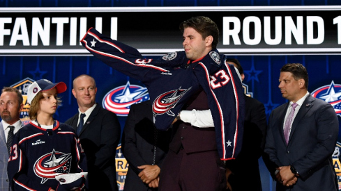 Columbus Blue Jackets draft pick Adam Fantilli puts on his sweater after being selected with the third pick in round one of the 2023 NHL Draft at Bridgestone Arena. 