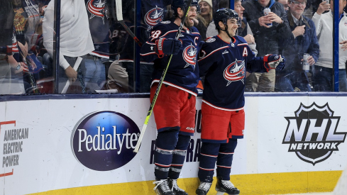 Boone Jenner celebrates with Johnny Gaudreau after scoring the game-winning goal against the New York Islanders