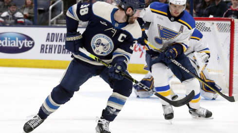 Columbus Blue Jackets' Boone Jenner knocks down a loose puck against St. Louis Blues' Brayden Schenn during the first period at Nationwide Arena.