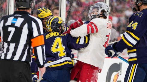 Ohio State Buckeyes forward Tate Singleton (13) hits Michigan Wolverines forward Gavin Brindley (4) during the first period of the Faceoff on the Lake outdoor NCAA men's hockey game at FirstEnergy Stadium.