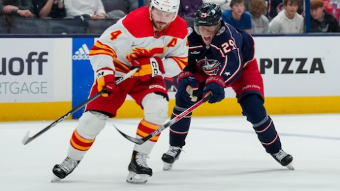 Calgary Flames defenseman Rasmus Andersson (4) skates with the puck against Columbus Blue Jackets right wing Patrik Laine (29) in the third period at Nationwide Arena.