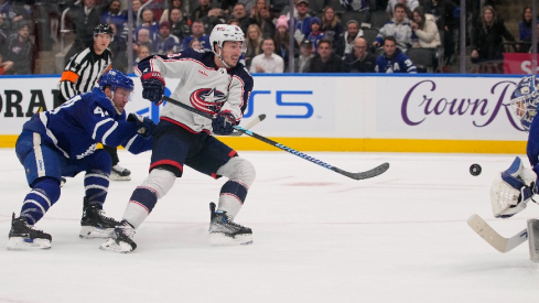 Columbus Blue Jackets defeneseman Zach Werenski (8) gets off a shot on Toronto Maple Leafs goaltender Ilya Samsonov (35) as defenseman Morgan Rielly (44) chases during the overtime at Scotiabank Arena.