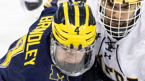 Michigan forward Gavin Brindley (4) and Notre Dame forward Niko Jovanovic (20) battle for position during the Michigan-Notre Dame NCAA hockey game on Saturday, November 12, 2022, at Compton Family Ice Arena in South Bend, Indiana. Michigan Vs Notre Dame
