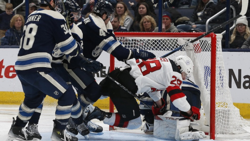 New Jersey Devils' Timo Meier falls onto Columbus Blue Jackets' Elvis Merzlikins during the second period at Nationwide Arena.