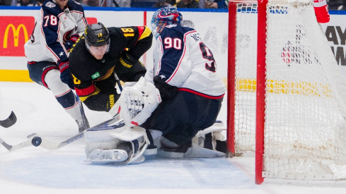 Columbus Blue Jackets defenseman Damon Severson (78) stick checks Vancouver Canucks forward Sam Lafferty (18) as goalie Elvis Merzlikins (90) makes a save in the second period at Rogers Arena.