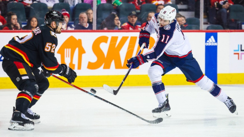 Columbus Blue Jackets center Adam Fantilli (11) shoots the puck against Calgary Flames defenseman MacKenzie Weegar (52) during the first period at Scotiabank Saddledome.