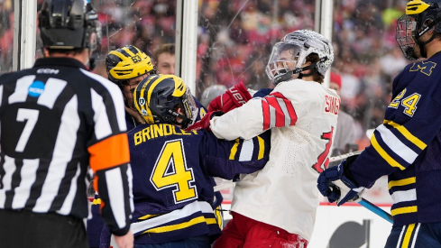 Ohio State Buckeyes forward Tate Singleton (13) hits Michigan Wolverines forward Gavin Brindley (4) during the first period of the Faceoff on the Lake outdoor NCAA men s hockey game at FirstEnergy Stadium.