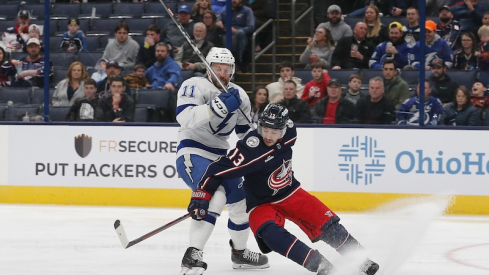 Columbus Blue Jackets' Johnny Gaudreau and Tampa Bay Lightning's Luke Glendening chase down a loose puck during the third period at Nationwide Arena.