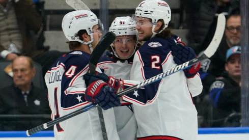 Columbus Blue Jackets defenseman Andrew Peeke (2) and forward Cole Sillinger (4) congratulate forward Kent Johnson (91) on his goal against the Toronto Maple Leafs during the first period at Scotiabank Arena.