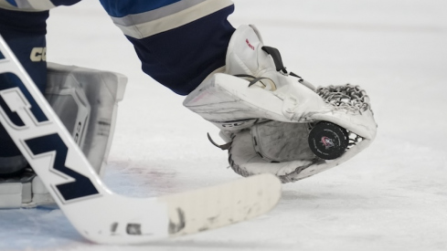 Columbus team logo is seen on the game puck as Columbus Blue Jackets' Jet Greaves makes a save in net against the New York Islanders in the third period at Nationwide Arena.