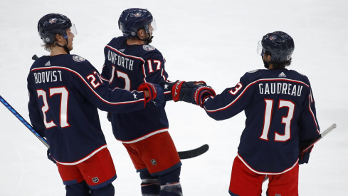 Justin Danforth celebrates with Adam Boqvist and Johnny Gaudreau