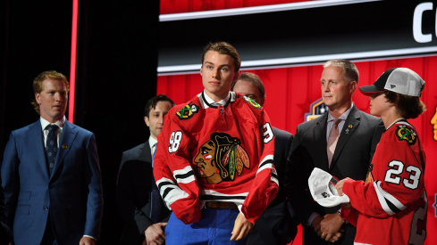 Connor Bedard puts on a Chicago Blackhawks jersey after being taken with the first pick in the 2023 NHL Draft 
