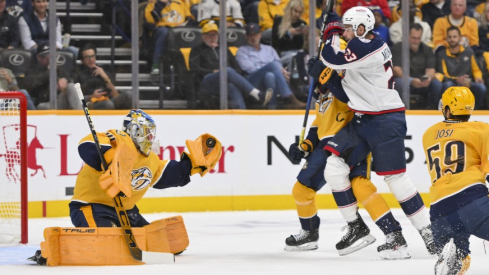 Oct 9, 2025; Nashville, Tennessee, USA; Nashville Predators goaltender Juuse Saros (74) makes a glove save from the shot of Columbus Blue Jackets center Sean Monahan (23) during the first period at Bridgestone Arena.