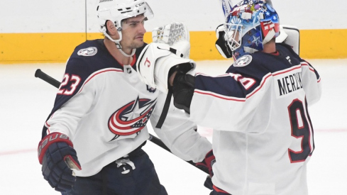 Oct 25, 2025; Pittsburgh, Pennsylvania, USA; Columbus Blue Jackets goalie Elvis Merzlikins (90) celebrates a win over the Pittsburgh Penguins with center Sean Monahan (23) after a shoot-out at PPG Paints Arena. The Blue Jackets won 5-4.