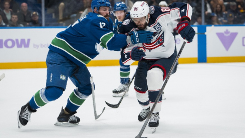 Nov 8, 2025; Vancouver, British Columbia, CAN; Vancouver Canucks defenseman Filip Hronek (17) checks Columbus Blue Jackets forward Kirill Marchenko (86) in the third period at Rogers Arena.
