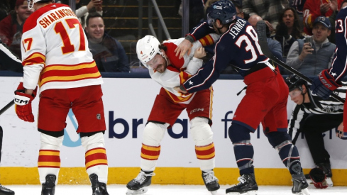 Jan 13, 2026; Columbus, Ohio, USA; Columbus Blue Jackets center Boone Jenner (38) and Calgary Flames defenseman Rasmus Andersson (4) fight during the second period at Nationwide Arena.
