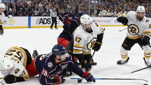 Mar 29, 2026; Columbus, Ohio, USA; Columbus Blue Jackets center Boone Jenner (38) reaches for the loose puck with Boston Bruins center Mark Kastelic (47) during the second period at Nationwide Arena.