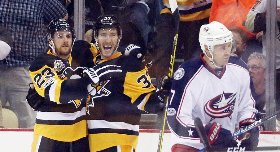 Pittsburgh Penguins left wing Scott Wilson (23) and right wing Carter Rowney (37) celebrate a goal by Rowney as Columbus Blue Jackets defenseman Jack Johnson (7) skates away.