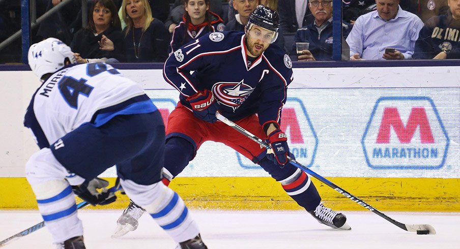 Columbus Blue Jackets left wing Nick Foligno skates with the puck against Winnipeg Jets defenseman Josh Morrissey.