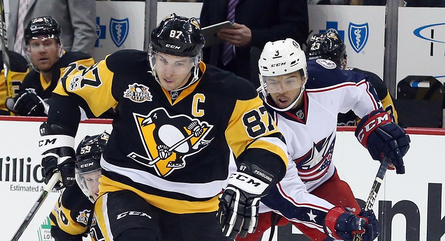 Pittsburgh Penguins center Sidney Crosby (87) chases the puck up ice ahead of right wing Jake Guentzel (59) and Columbus Blue Jackets defenseman Seth Jones (3).