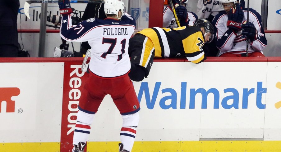 Nick Foligno checks Patric Hornqvist into away team bench