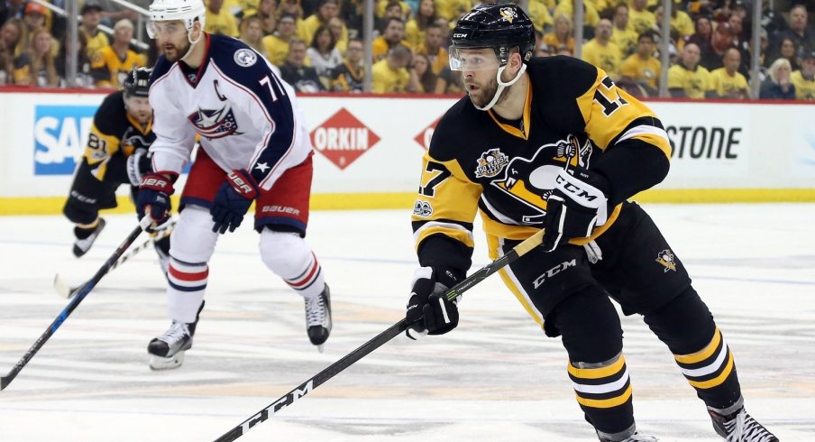 Bryan Rust skates down the ice with Nick Foligno in close pursuit
