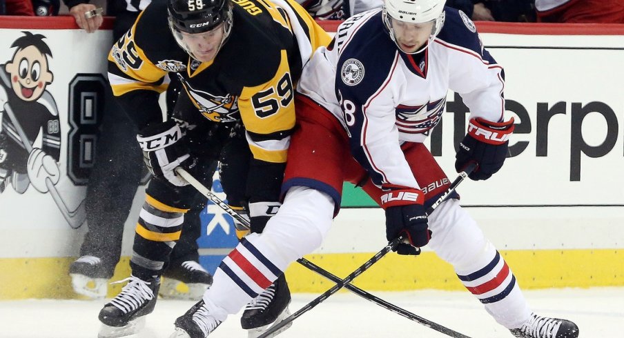 Oliver Bjorkstrand and Jake Guentzel fight for the puck